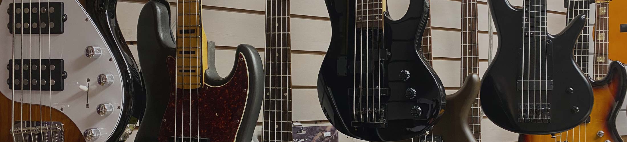 image of bass guitars hanging up at WestSide Music in Waipahu